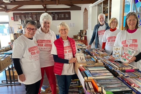 Members of the Friends of Library at last years book fair surrounded by tables full of books