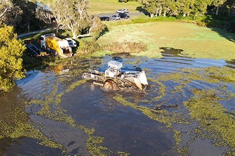 high view of floating weed harvester on lake