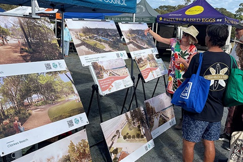 woman pointing to images of beach displayed on easels.