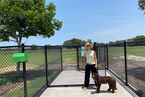 female holding medium-size brown dog on lead 