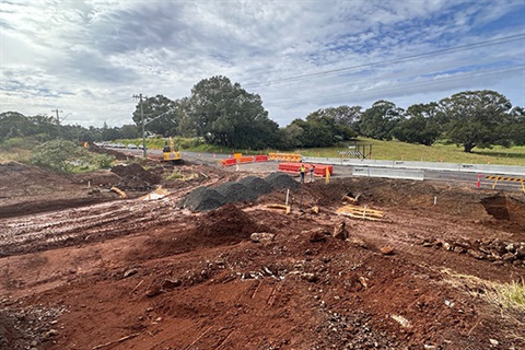 excavated pile of red dirt with bitumen road in background