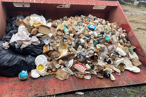 hundreds of used coffee cups in a pile