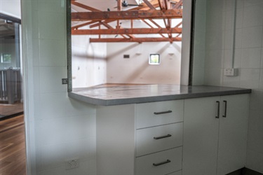 Kitchen space looking through internal window into the main area